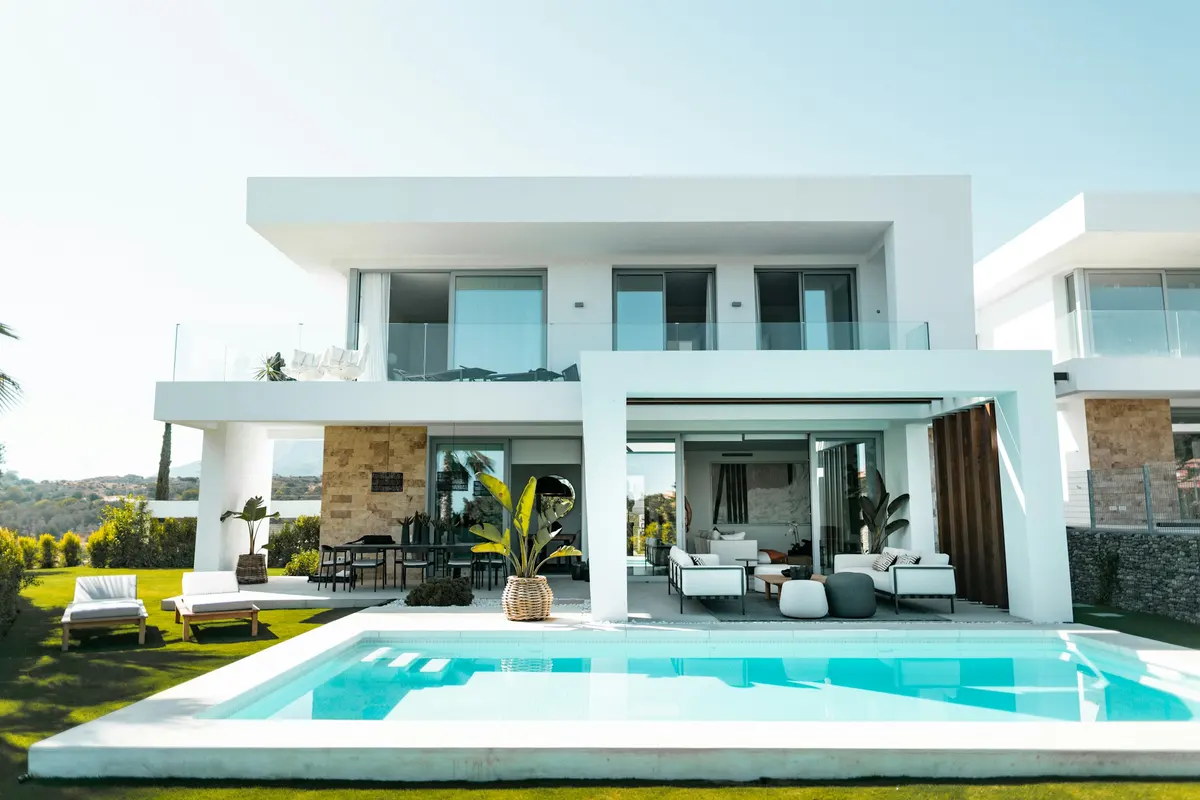 Contemporary white villa opening onto a swimming pool and landscaped garden